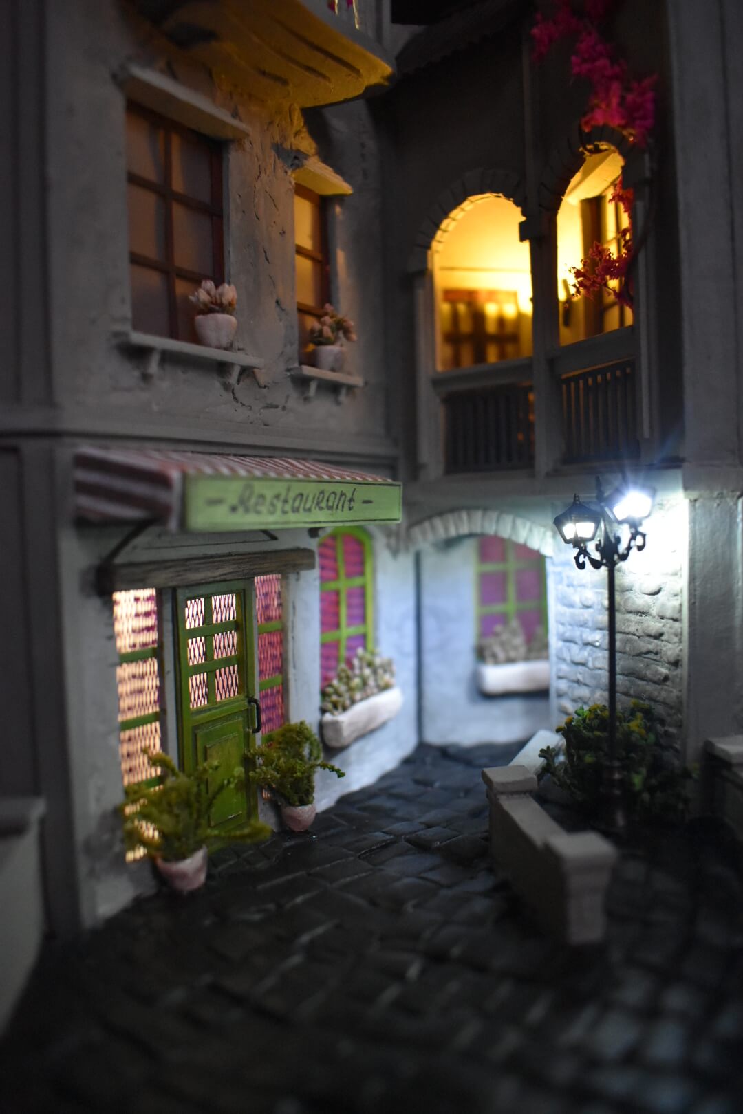 Book nook insert HandiCraftArt depicting a cosy French restaurant, creating an atmosphere of Parisian charm and romance. It features built-in lighting and a mirror effect.