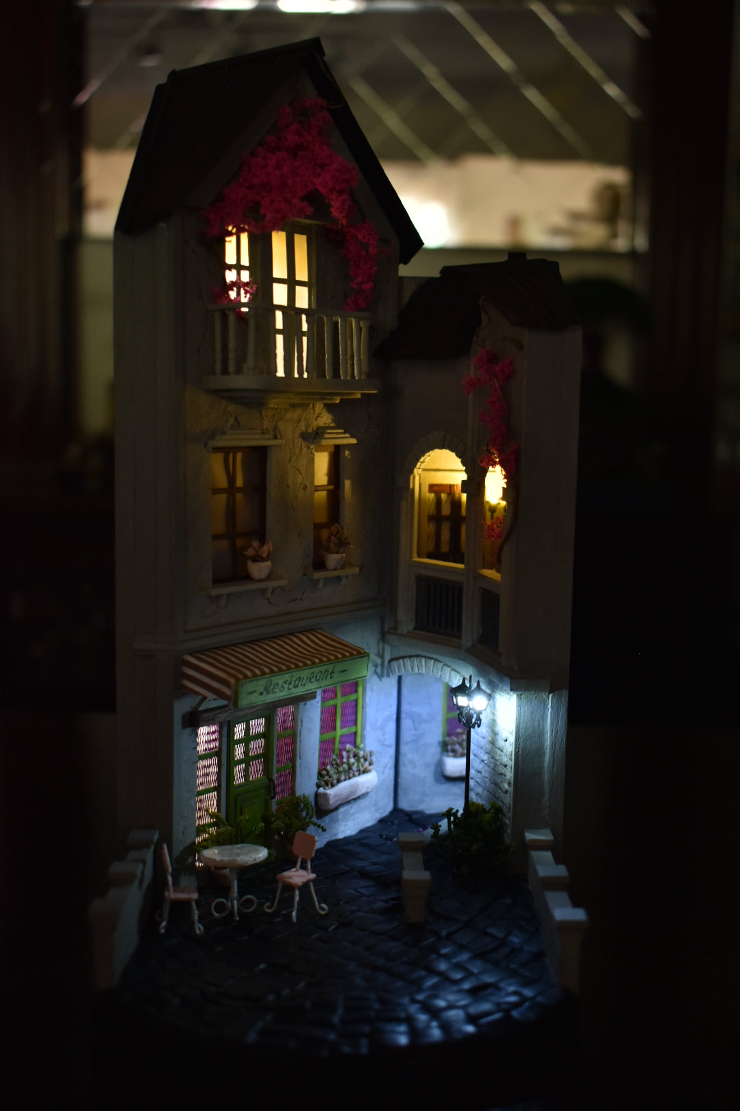 Book nook insert HandiCraftArt depicting a cosy French restaurant, creating an atmosphere of Parisian charm and romance. It features built-in lighting and a mirror effect.