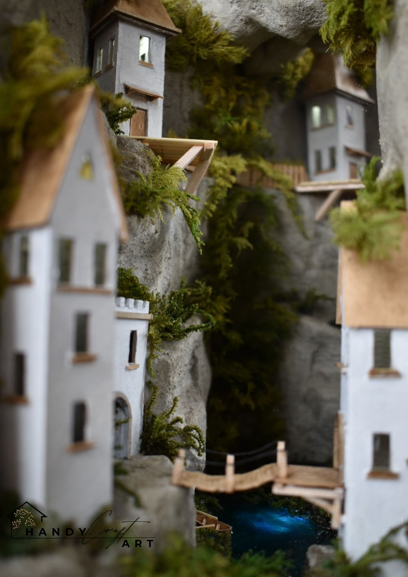 Booknook of a quaint city with houses and a bridge against a rocky cliffside.