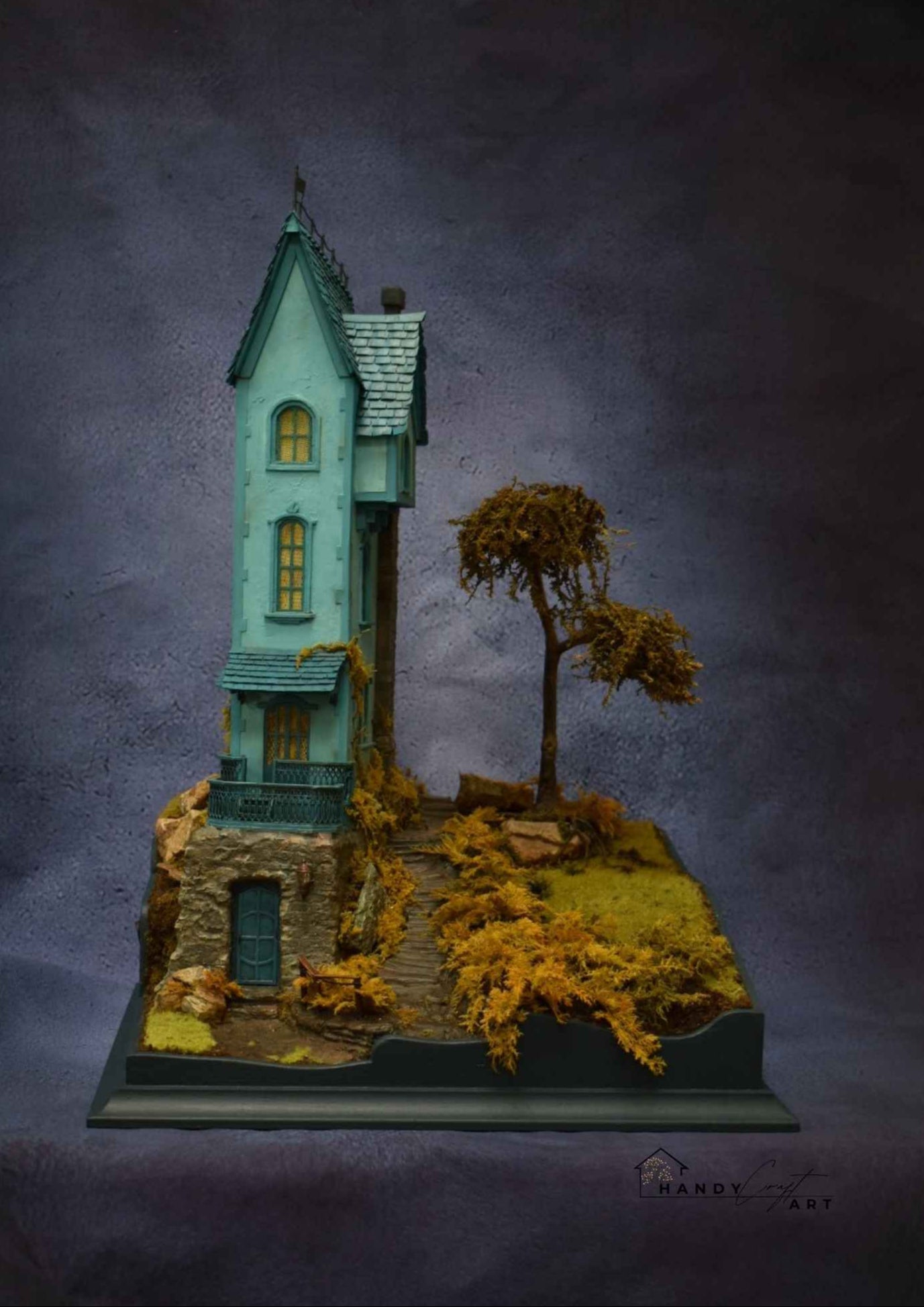 Collectible handmade diorama by HandiCraftArtIE. Model of a miniature house with a tree on a dark background. 