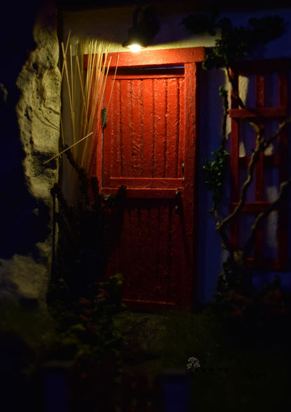 Diorama with Red door illuminated by a light source in a dark setting